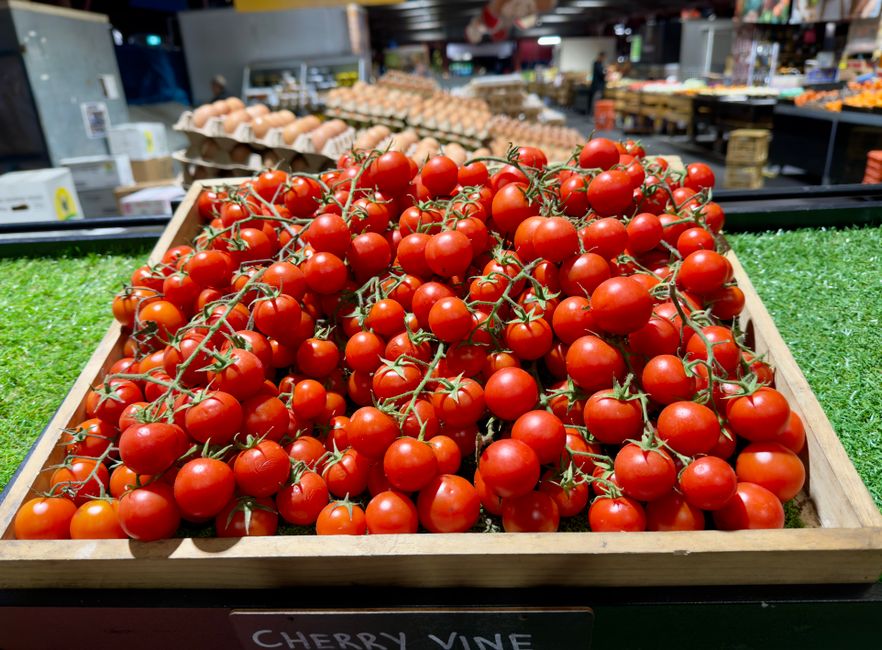 A vibrant display of fresh cherry vine tomatoes in a Melbourne market. Perfect for culinary use.