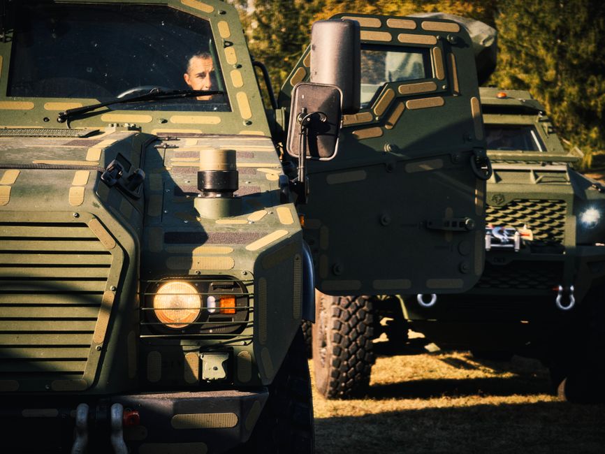 Armored military vehicle with camouflage and driver, ready for action.