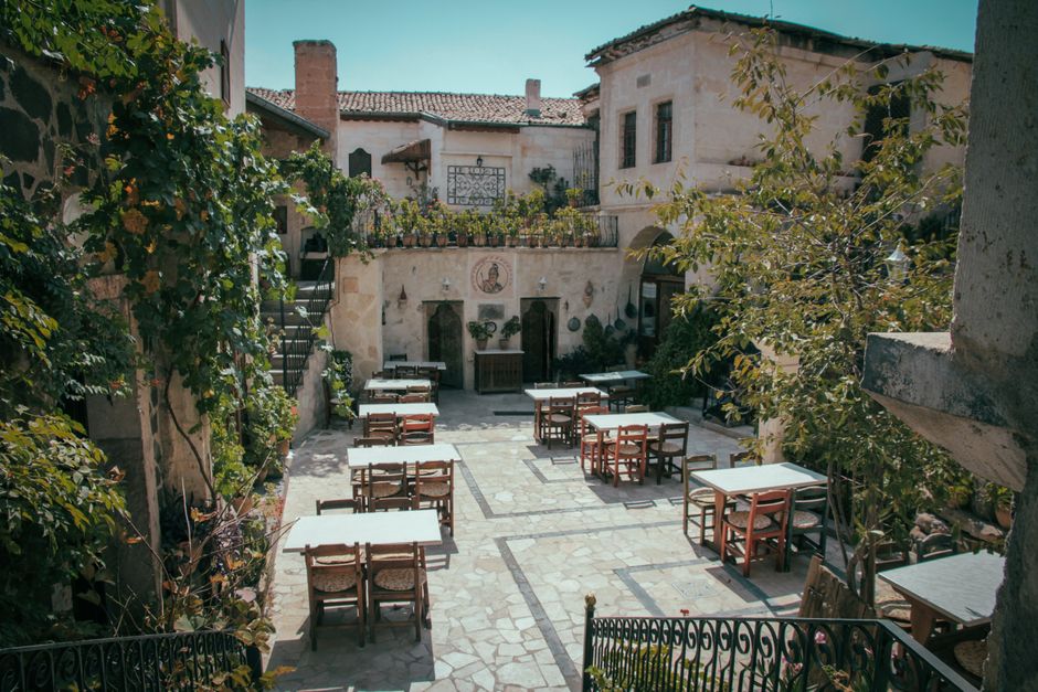 Rustic courtyard with vintage architecture and outdoor seating, perfect for dining.