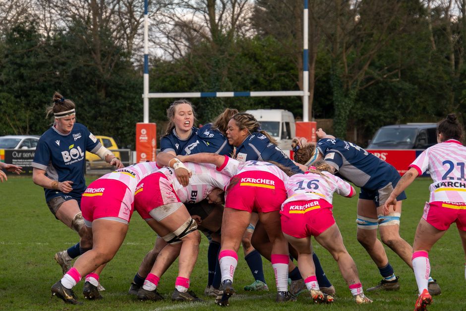 Exciting women's rugby match showcasing athleticism and teamwork on a grassy field.