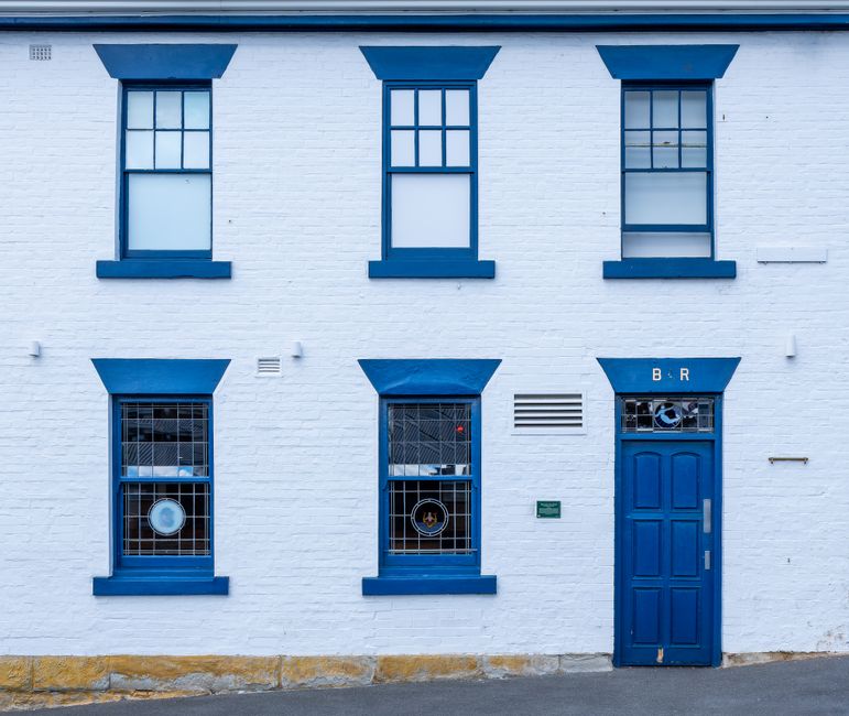Historic blue and white building facade in Hobart, Tasmania, showcasing striking windows and doors.